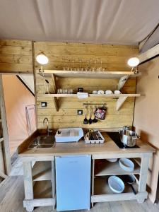 uma cozinha com um balcão e um lavatório num quarto em Glamping Camping Rivabella em Lecco