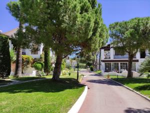 una calle frente a una casa con árboles en BFA - R149 Casa adosada Alorda con piscina comunitaria, en Calafell