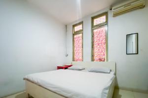 a white room with a bed and two windows at Wisma Syariah Lambhuk Banda Aceh RedPartner in Banda Aceh +16 photos