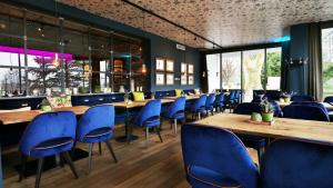 a restaurant with wooden tables and blue chairs at FAVORITE Parkhotel I Spa - Business - Fine Dining in Mainz