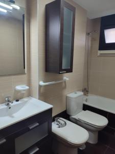 La salle de bains est pourvue de toilettes, d'un lavabo et d'un miroir. dans l'établissement Apartamento Florida-Natura Oviedo, à Oviedo