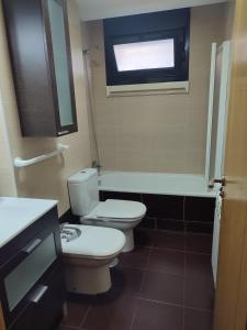 La salle de bains est pourvue de toilettes, d'une baignoire et d'une fenêtre. dans l'établissement Apartamento Florida-Natura Oviedo, à Oviedo
