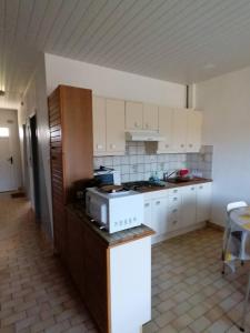 a kitchen with white cabinets and a stove top oven at Gîtes Les Courrèges in Vézac