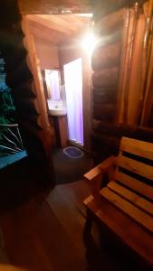 ein Bad mit einer Bank, einem Waschbecken und einem Fenster in der Unterkunft Nawgala Eco Cottage 