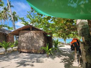 a building on the beach with a bike parked next to it at Bice Camp Darocotan in El Nido