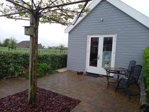 a patio with a table and a small house at Room by the sea in Zoutelande