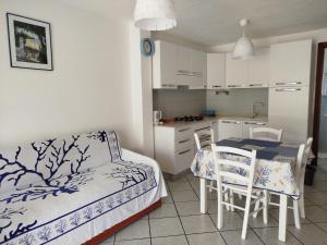 a room with a table and chairs and a kitchen at Oasi Boungaville in Porto San Paolo