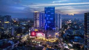 a city skyline at night with a tall building at Apartment Podomoro Medan in Medan