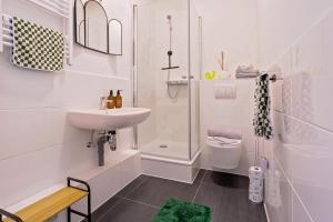 a white bathroom with a sink and a shower at Boarding & Monteur Apartment CMTZ in Chemnitz