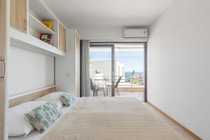 een slaapkamer met een bed en uitzicht op de oceaan bij Enyoj Marjan, Beaches and View in Split
