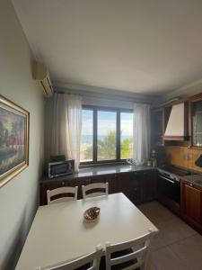 a kitchen with a white table and chairs and a window at Peak Apartment Sea View in Vollga Durres #3 in Durrës