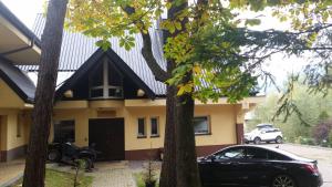 a black car parked in front of a house at Willa Sunshine Zakopane Chalet in Zakopane