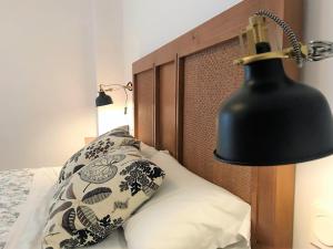 Cama con lámpara negra y almohada en Apartamento En El Centro De Ronda, en Ronda