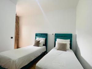 twee bedden in een kamer met witte muren bij Green coastline CHMAALA in Ifargane