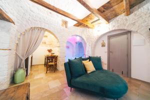 a living room with a green couch in a stone wall at Soave Relax & Wellness in Alberobello +20 photos