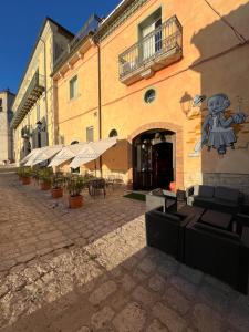 a building with tables and umbrellas in a courtyard at Perbacco in SantʼAngelo Limosano