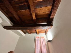 a wooden ceiling in a room with a window at Home 28 appartamento nel cuore di Modena centro in Modena