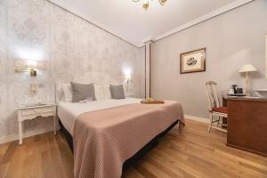 a bedroom with a large bed and a table at Hotel Infanta Isabel by Recordis Hotels in Segovia