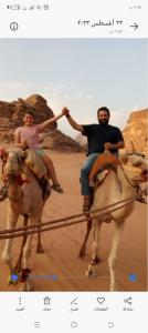 Disah的住宿－Omar Camp Wadi Rum，男人和女人在沙漠里骑马