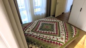 a quilt on the back of a bed in a room at Žalio kalno apartamentai in Kaunas
