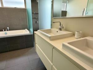 a bathroom with two sinks and a mirror at Beachfront Bliss in Cape Town +10 photos
