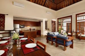 cocina y sala de estar con mesa y sillas en Jimbaran Beach Villas by Nakula en Jimbaran