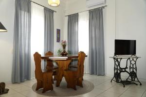 un tavolo da pranzo con sedie e una TV di Elegant central apartment a Heraklion