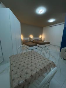 a room with two beds and a table and chairs at Angela's dreams in Conversano