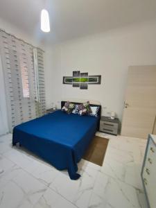 ein Schlafzimmer mit einem blauen Bett in einem weißen Zimmer in der Unterkunft Amedeo in Civitanova Marche