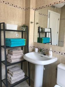 a bathroom with a sink and a mirror and towels at Beach Side Heaven in Fuengirola
