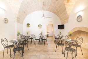 a large room with tables and chairs in a building at Masseria San Nicola Savelletri - B&B in Fasano