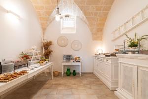 una grande cucina con armadi bianchi e bancone di Masseria San Nicola Savelletri - B&B a Fasano
