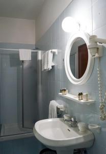 a bathroom with a sink and a shower and a mirror at Lake Hotel Ifigenia in Nago-Torbole