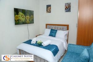 a hotel room with a bed and a chair at Calumet Suites Accommodation in Ngong