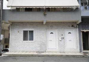 un edificio in mattoni bianchi con due porte bianche di Elegant central apartment a Heraklion