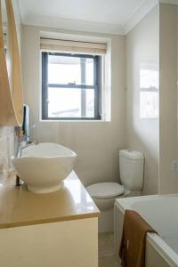 een badkamer met een wastafel, een toilet en een raam bij Kirribilli Kanangra in Sydney