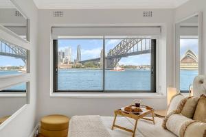 a living room with a large window with a view of a bridge at Kirribilli Kanangra in Sydney