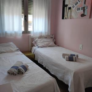 2 Betten in einem Zimmer mit Handtüchern darauf in der Unterkunft Apartamento in Valencia