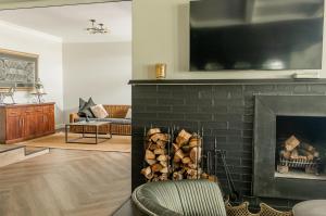 a living room with a fireplace with a tv above it at The Wesley Boutique Hotel & Spa in Johannesburg