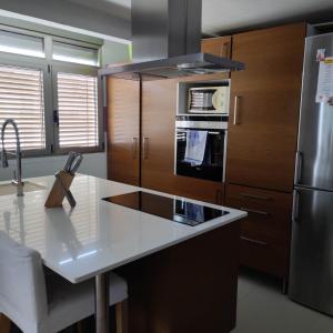 eine Küche mit einer weißen Arbeitsplatte und einem Kühlschrank in der Unterkunft Apartamento in Valencia