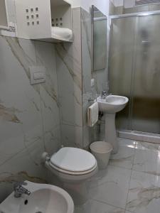 a white bathroom with a toilet and a sink at Angela's dreams in Conversano