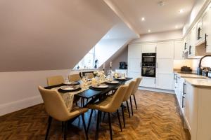 a dining room with a black table and chairs at Longshaw Loft in Buxton