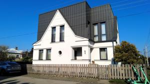 una casa blanca con techo negro en Žalio kalno apartamentai en Kaunas