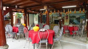 un restaurante con mesas rojas y sillas con jarrones amarillos. en Homestay Minh Ngoc, 