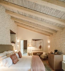 a bedroom with a large bed and a stone wall at Castell de Vallgornera in Girona
