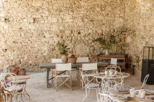 a room with a table and chairs and a stone wall at Hotel Castell de Vallgornera in Girona