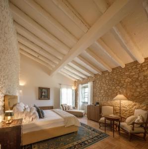 a bedroom with a large bed and a stone wall at Castell de Vallgornera in Girona