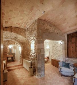 a large living room with a stone wall at Castell de Vallgornera in Girona