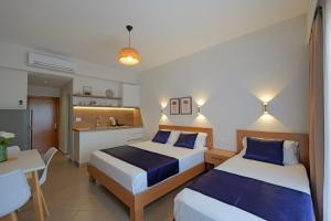 une chambre d'hôtel avec deux lits et une cuisine dans l'établissement Villa Pargua, à Borsh