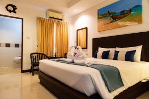 un dormitorio con una cama con dos animales de peluche en Q Victory Patong Hotel, en Patong Beach